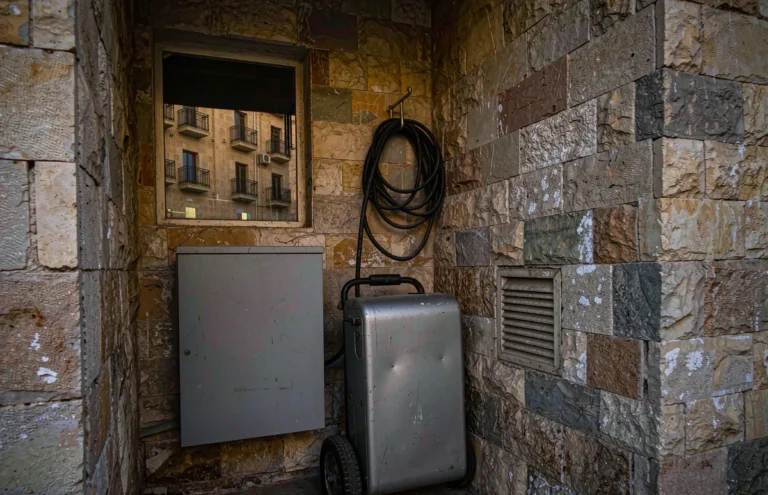 Step down transformer beside a portable generator in a stone walled Yemeni utility room
